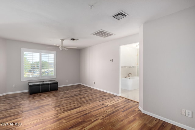 unfurnished room with ceiling fan and dark wood-type flooring