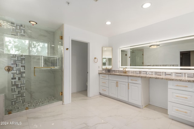 bathroom with a shower with door, vanity, and toilet