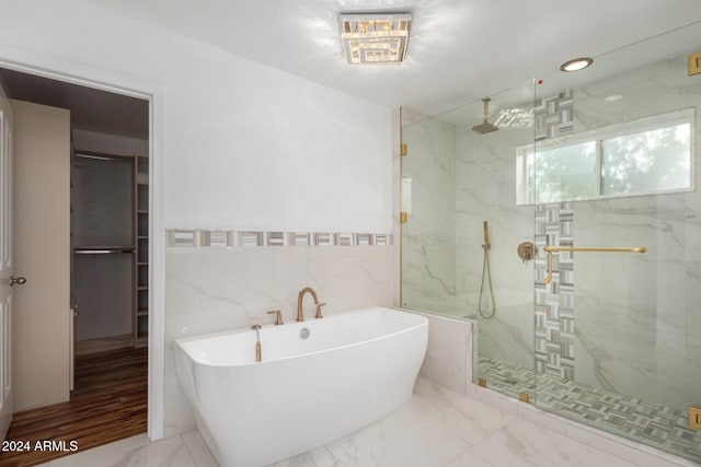 bathroom with tile walls and independent shower and bath