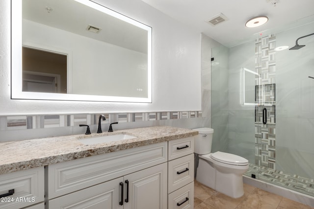 bathroom featuring tile patterned flooring, vanity, toilet, and an enclosed shower