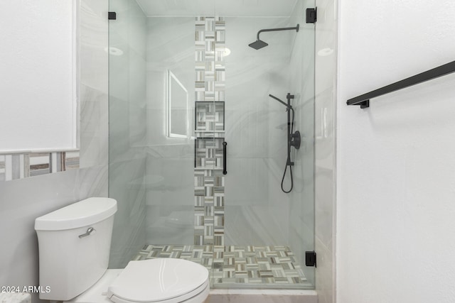 bathroom featuring toilet and an enclosed shower