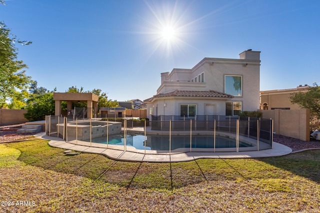 view of pool featuring a lawn and an in ground hot tub