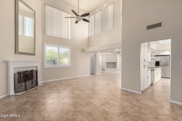 unfurnished living room with a high ceiling and ceiling fan