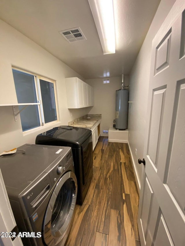 laundry room with dark hardwood / wood-style flooring, cabinets, gas water heater, and independent washer and dryer