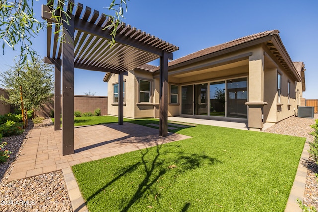 rear view of property featuring a yard, a pergola, a patio area, and central AC