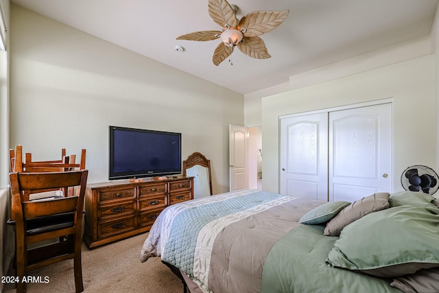 carpeted bedroom with ceiling fan, a closet, and vaulted ceiling