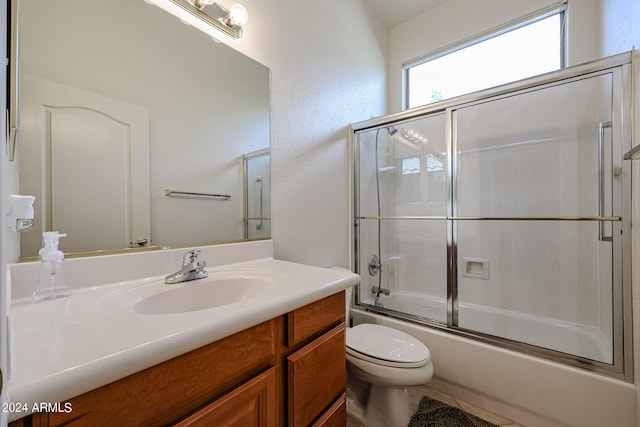 full bathroom with shower / bath combination with glass door, vanity, and toilet