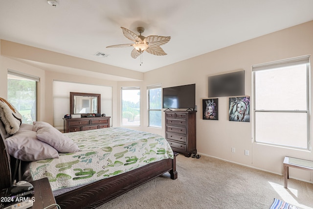 carpeted bedroom with ceiling fan and multiple windows