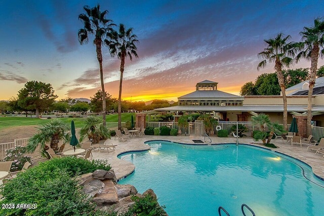 pool at dusk with a gazebo and a patio