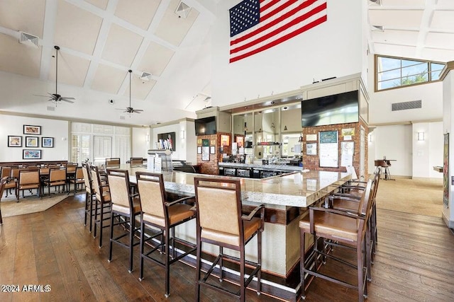 bar with ceiling fan, dark hardwood / wood-style floors, a high ceiling, and a wealth of natural light