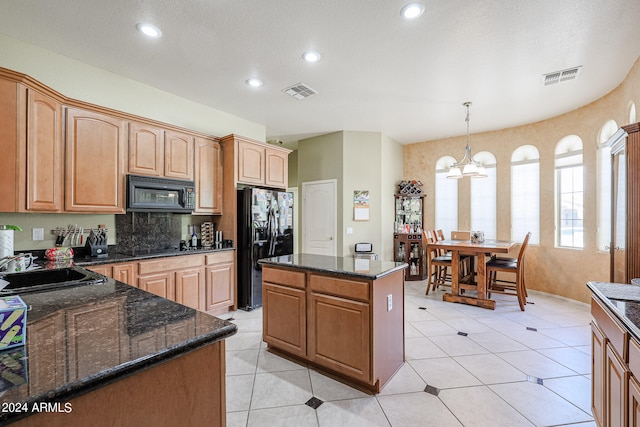 kitchen with hanging light fixtures, black appliances, a center island, an inviting chandelier, and sink