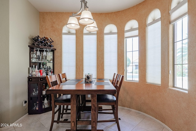 tiled dining space featuring an inviting chandelier and a wealth of natural light