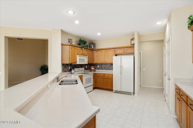 kitchen featuring white appliances, decorative backsplash, sink, and kitchen peninsula