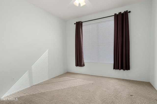 carpeted spare room featuring ceiling fan