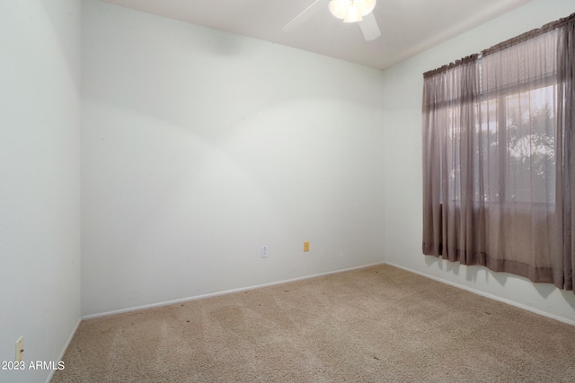 carpeted spare room featuring ceiling fan