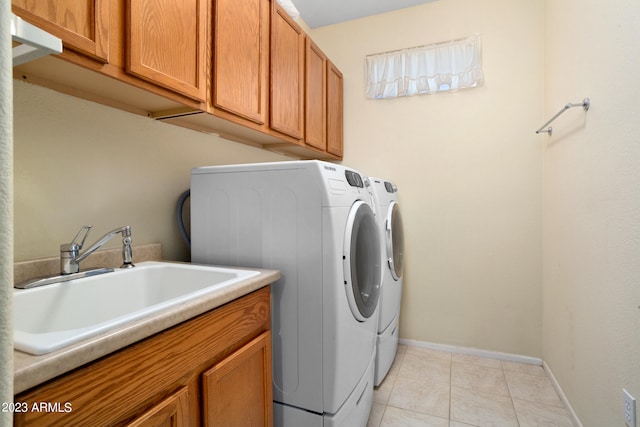 washroom with cabinets, sink, separate washer and dryer, and light tile patterned floors