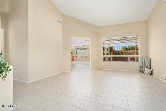 tiled spare room featuring vaulted ceiling