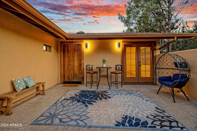 exterior entry at dusk with a patio area and french doors