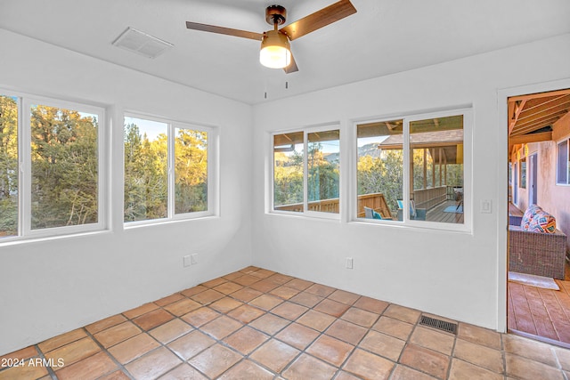 unfurnished sunroom featuring ceiling fan