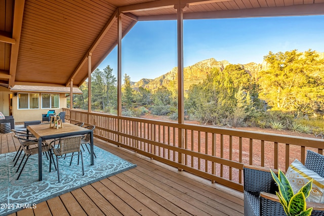 unfurnished sunroom featuring a mountain view and vaulted ceiling