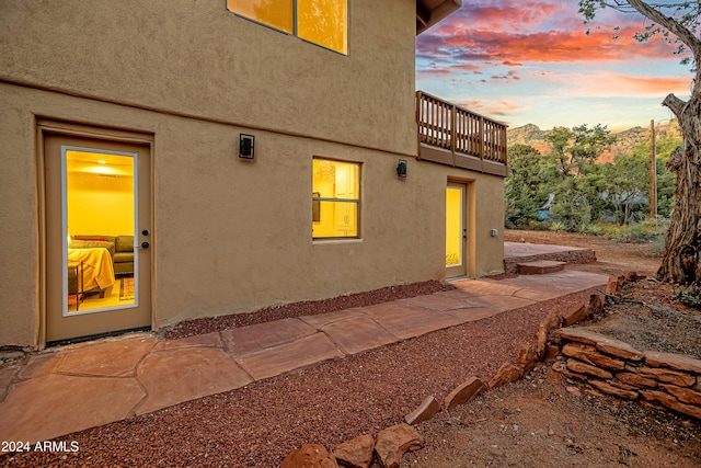 exterior entry at dusk with a balcony