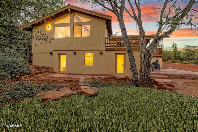 back house at dusk featuring a yard