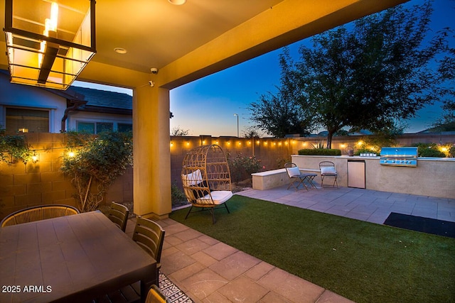 patio terrace at dusk featuring area for grilling, a lawn, a grill, and outdoor dining area