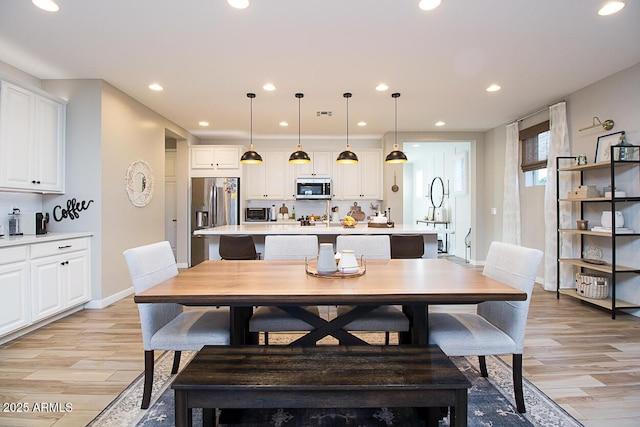 dining area with recessed lighting, light wood-style floors, and baseboards