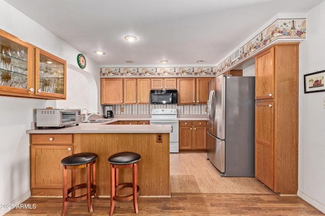 922 S 80th St, Mesa, AZ 85208 - kitchen with white electric stove, freestanding refrigerator, black microwave, a peninsula, and a sink
