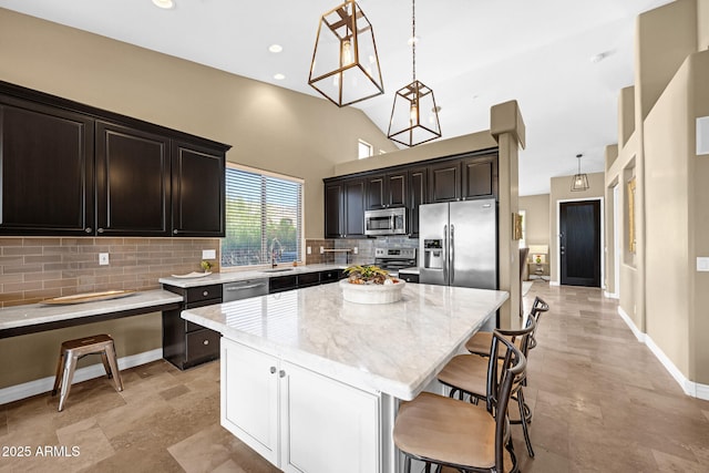 10623 E Acacia Dr, Scottsdale, AZ 85255 - kitchen featuring a center island, a kitchen bar, a sink, stainless steel appliances, and tasteful backsplash