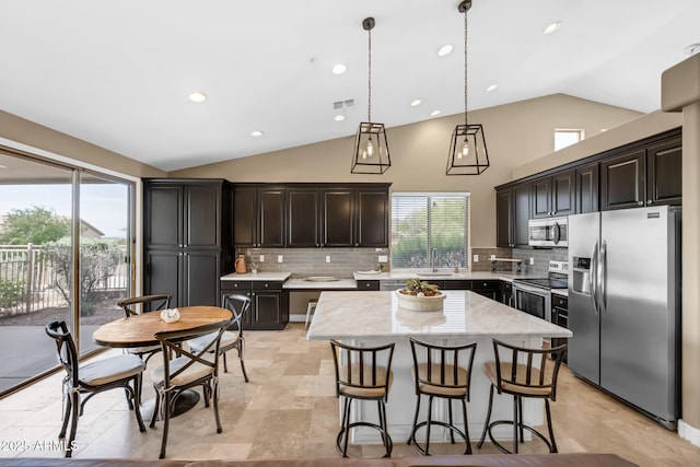 10623 E Acacia Dr, Scottsdale, AZ 85255 - kitchen with visible vents, a sink, decorative backsplash, vaulted ceiling, and stainless steel appliances