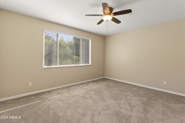 carpeted spare room with ceiling fan