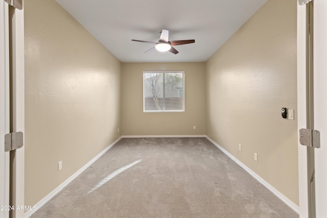 spare room featuring light colored carpet and ceiling fan