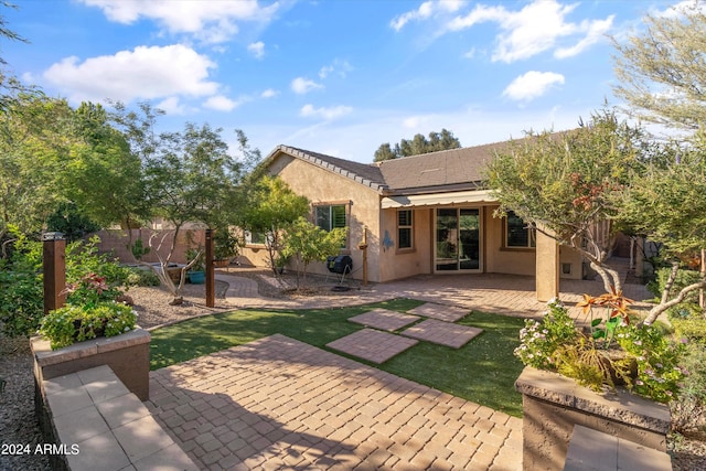 rear view of house featuring a patio area and a lawn