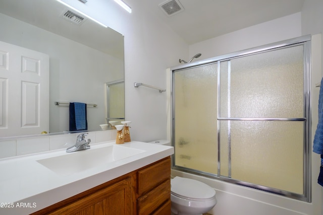 full bathroom featuring shower / bath combination with glass door, vanity, and toilet