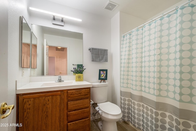 bathroom featuring curtained shower, vanity, and toilet