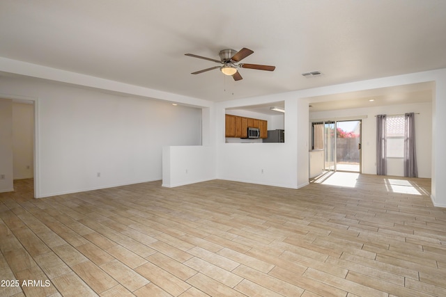 unfurnished living room featuring light hardwood / wood-style flooring and ceiling fan