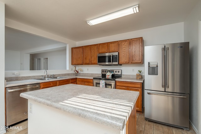 kitchen featuring stainless steel appliances, a kitchen island, and sink