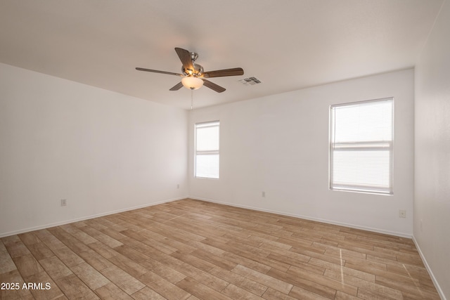 empty room with ceiling fan and light hardwood / wood-style floors