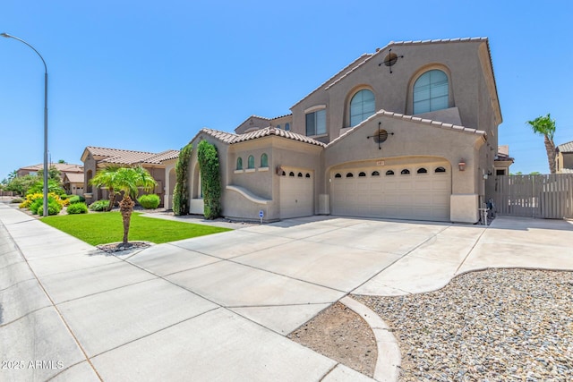 mediterranean / spanish-style house featuring concrete driveway, a tiled roof, and stucco siding