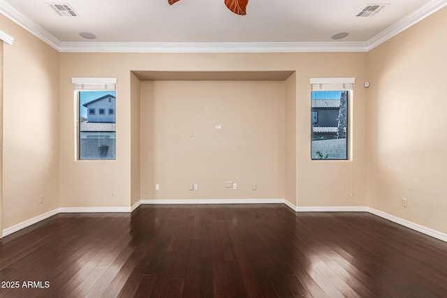 spare room featuring crown molding, dark wood finished floors, visible vents, and baseboards