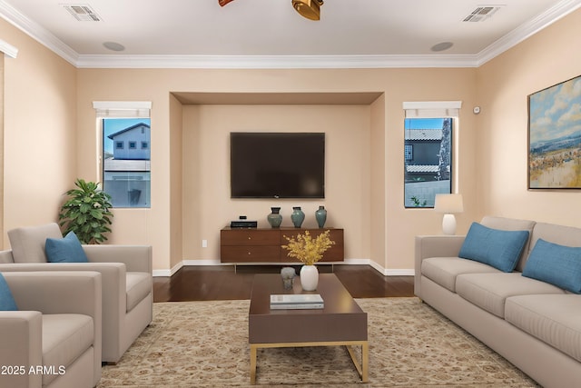 living area with baseboards, visible vents, and wood finished floors