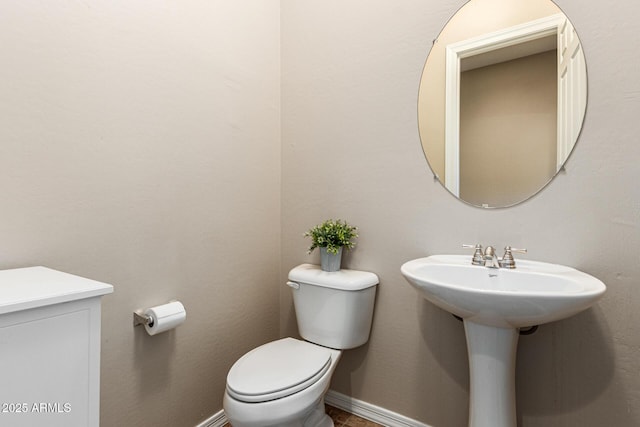 bathroom with toilet and baseboards