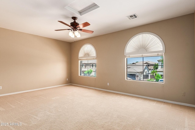 spare room featuring attic access, light carpet, visible vents, and baseboards