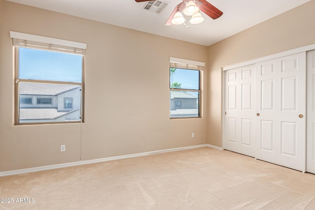 unfurnished bedroom featuring light colored carpet, a closet, visible vents, and baseboards