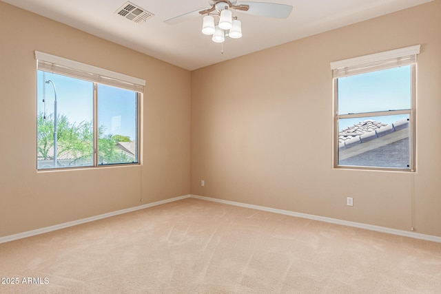 empty room featuring baseboards, visible vents, and light colored carpet