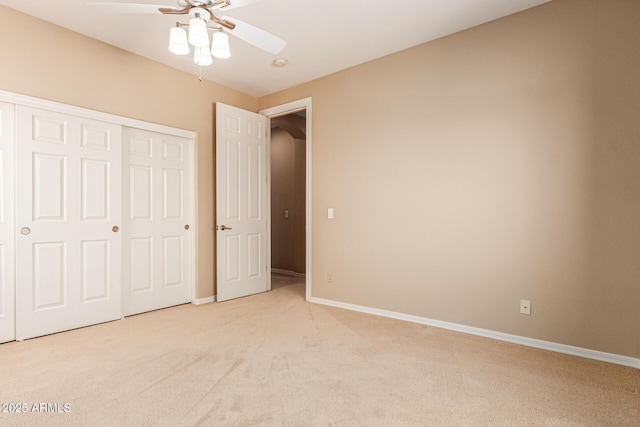 unfurnished bedroom with baseboards, a closet, a ceiling fan, and light colored carpet