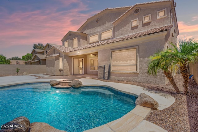 back of property with a fenced in pool, a fenced backyard, a patio, and stucco siding