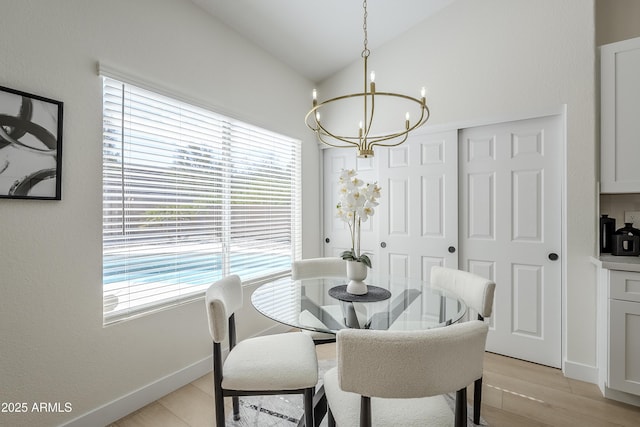 dining area with an inviting chandelier, lofted ceiling, and light wood-type flooring