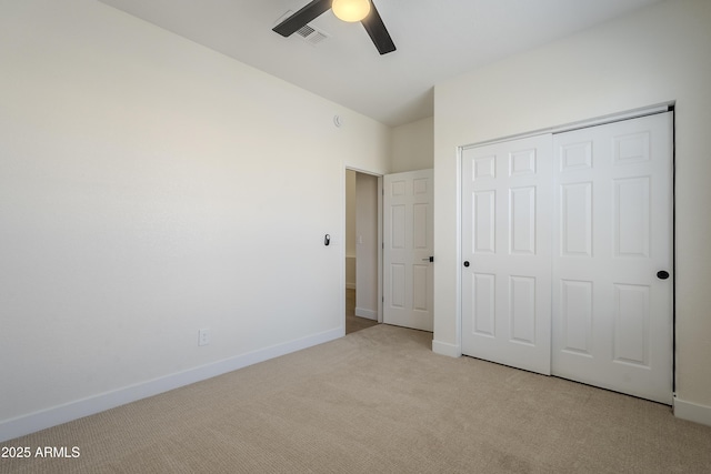 unfurnished bedroom with light carpet, a closet, and ceiling fan